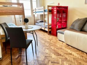 un soggiorno con tavolo, letto e letti a castello di Zen Hostel by Central Market a Budapest