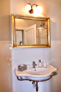 uma casa de banho com um lavatório e um espelho em Castellinaria em Lari