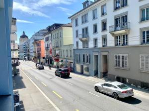 ulica z samochodami jadącymi ulicą z budynkami w obiekcie City Apartment - close to town - by PA w Lucernie