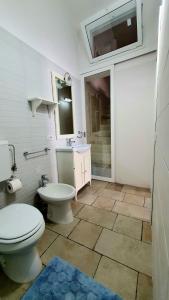 La salle de bains est pourvue de toilettes, d'un lavabo et d'un miroir. dans l'établissement Lu Salentu Chalet Beach, à Marina di Mancaversa