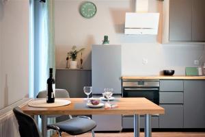 a kitchen with a table with two glasses of wine at Piotrkowska 44 Apartment in Łódź