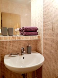 La salle de bains est pourvue d'un lavabo, d'un miroir et de serviettes. dans l'établissement Apartmán Severanka, à Vysoké Tatry