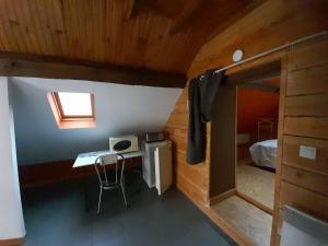 a room with a desk and a bed in a cabin at La cabane: Chambre double, salle de bain privée in Vatan