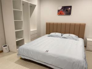 een slaapkamer met een groot bed met witte lakens bij Homestay Greenbay Garden Hạ Long in Ha Long