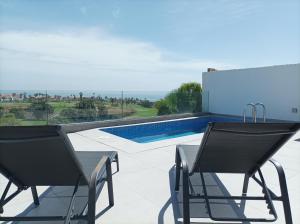 un patio con 2 sillas y una piscina en Joy Tenerife Charming House, en San Miguel de Abona