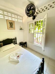 a bedroom with a bed and a window at Hotel Mangata in Cartagena de Indias