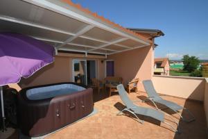 a patio with chairs and a hot tub and an umbrella at Relax apartment near Opatija, Sauna, jacuzzi in Marinići