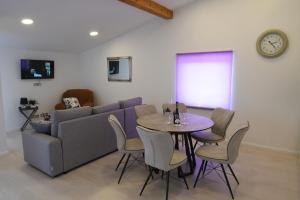 a living room with a couch and a table with chairs at Relax apartment near Opatija, Sauna, jacuzzi in Marinići