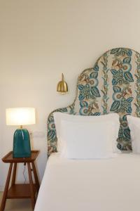 阿爾熱祖爾的住宿－Praia do Canal Nature Retreat，一间卧室配有一张床和一张桌子上的台灯