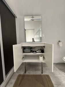 a white cabinet with a mirror in a bathroom at L'Entrepotes in Rethel