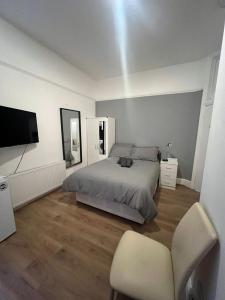 1 dormitorio con 1 cama, 1 silla y TV en Private Self Contained Studio In The Heart Of Golders Green en Londres