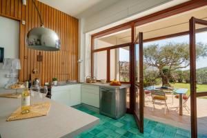 una cucina con una grande finestra e un tavolo di Villa Arrecifes a Fertilia