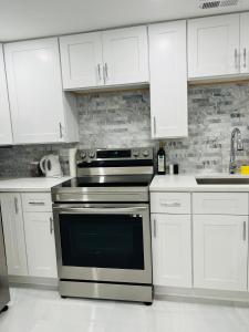 uma cozinha com um fogão e armários brancos em Perfect place to enjoy the city or just relax em Chicago