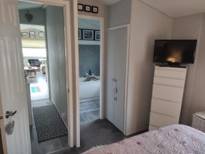 a bedroom with a bathroom with a tub and a television at "Dew Drop Inn" in Port Seton