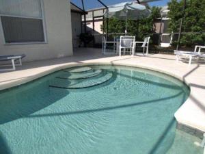 a swimming pool with blue water in a yard at Turkey Oak Villa IR021 in Kissimmee