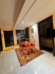 une salle à manger avec une table et des chaises sur un tapis dans l'établissement Luxury apartment 2 in the heart of Gueliz, Wifi, Pool, à Marrakech