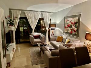 a living room with two couches and a television at Flamingo Apartment Coto Real La Duquesa in Manilva