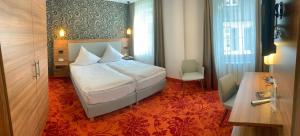 um quarto com uma cama e uma cadeira num quarto em Hotel Felsenkeller em Rüdesheim am Rhein