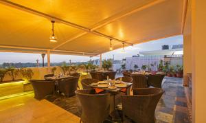 a restaurant with tables and chairs on a roof at Treebo Trend Chandigarh Grand in Chandīgarh