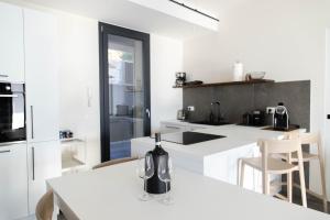 una cucina con banconi bianchi e ripiani bianchi di RITA apartments a Bardolino