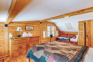 a bedroom with a bed in a room with wooden walls at Great Pond House in Belgrade