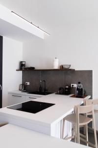 cocina con fregadero y encimera con taburetes en RITA apartments, en Bardolino