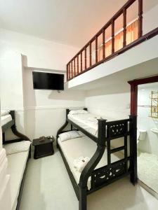 Una habitación con tres literas y una escalera. en Hotel Mangata, en Cartagena de Indias