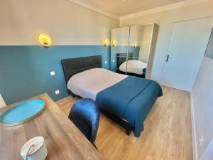 1 dormitorio con 1 cama y 1 mesa en una habitación en Andreossy, en Antibes