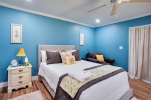 a bedroom with blue walls and a bed and a nightstand at Saint Helena Island Getaway with Marsh Views! in St. Helena Island