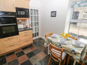 a kitchen with a table with a table cloth on it at Ty Coets, Morfa Farm in Llantwit Major