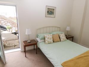 a bedroom with a bed with pillows and a balcony at Ty Coets, Morfa Farm in Llantwit Major