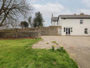 a white house with a stone wall and a yard at Ty Coets, Morfa Farm in Llantwit Major