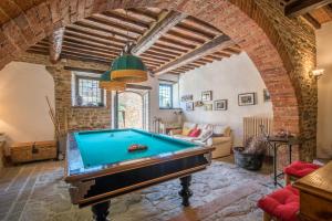 una mesa de billar en una sala de estar con un arco en Casale Rosennano - Loggia, en Rosennano