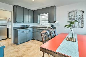 a kitchen with gray cabinets and a red table in it at Charming Cave City Vacation Rental with Fire Pit! in Cave City