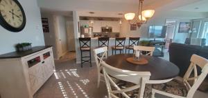 cocina y sala de estar con mesa y reloj en AMAZING LAKE VIEW! GORGEOUS SUNSET! ON MAIN CHANNEL! 3BR/2BA-SLEEPS 6-8 en Lake Ozark