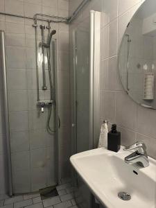 uma casa de banho com um chuveiro, um lavatório e um espelho. em Käringöns Vandrarhem em Käringön