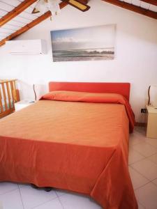 um quarto com uma cama com um cobertor laranja em Casa sul mare in Sicilia, Acireale-Stazzo em Acireale