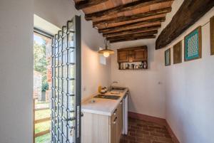 cocina con fregadero y encimera con ventana en Casale Rosennano - Riserva en Rosennano