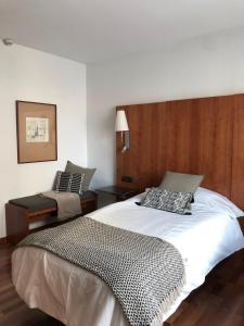 a bedroom with a large white bed and a chair at Micampus Pamplona in Pamplona