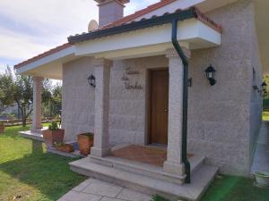 ein kleines Haus mit einer Veranda mit einer Tür in der Unterkunft Casa da Viña 