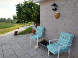 zwei blaue Stühle neben einer Wand in der Unterkunft Casa da Viña 
