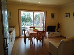 a living room with a table and chairs and a television at Casa da Viña in Guillade