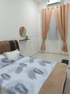 a bedroom with a bed with a black and white blanket at TGG Homestay with Netflix in Kuala Terengganu