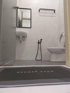 TGG Homestay with Netflix في كوالا ترغكانو: حمام مع حوض ومرحاض في الغرفة