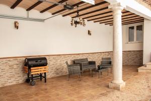 a patio with a table and chairs and a grill at Casa Rural Los Eneares in Ossa de Montiel
