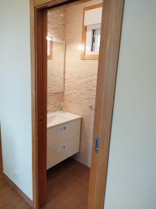 ein Bad mit einem Waschbecken und einem Spiegel in der Unterkunft Casa da Viña 