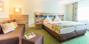Habitación de hotel con cama y sofá en Ambient Hotel am Europakanal, en Fürth