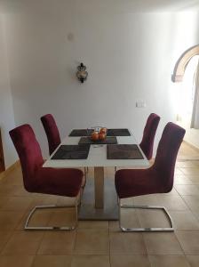 a dining room with a table and red chairs at Villa Costa Nova Javea in Balcon del Mar