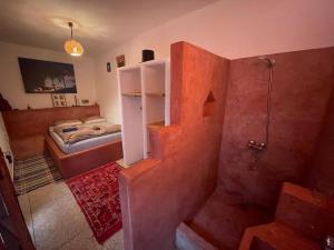 a small bathroom with a shower and a bed at SALAS waveclimbing company in Sidi Ifni