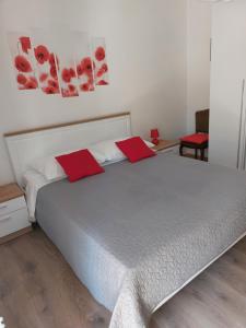um quarto com uma cama grande e almofadas vermelhas em Soba Ana em Cres